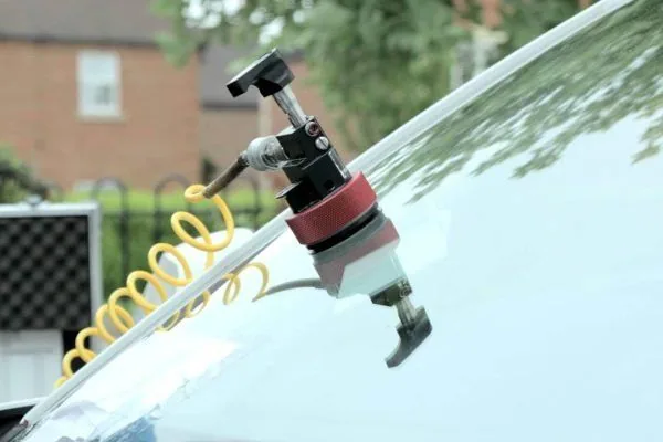 Windshield chip repair tool attached to auto glass